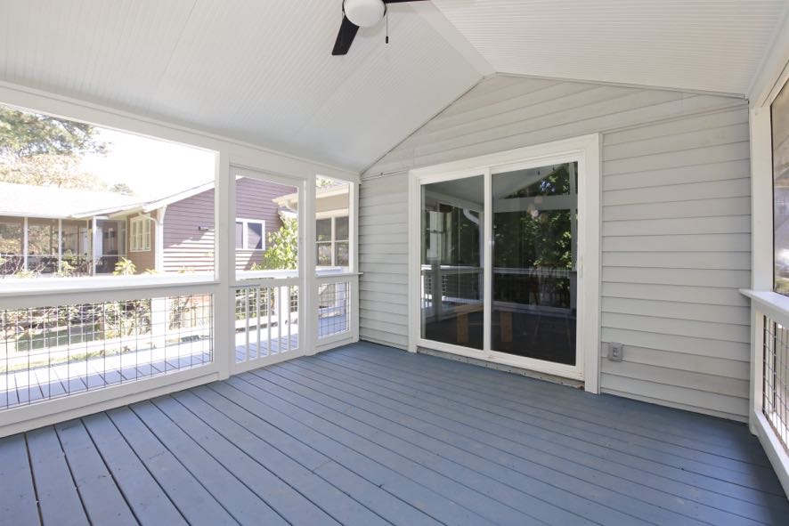 Finished screened porch interior showing sliding glass door entry and vaulted ceiling in Durham NC