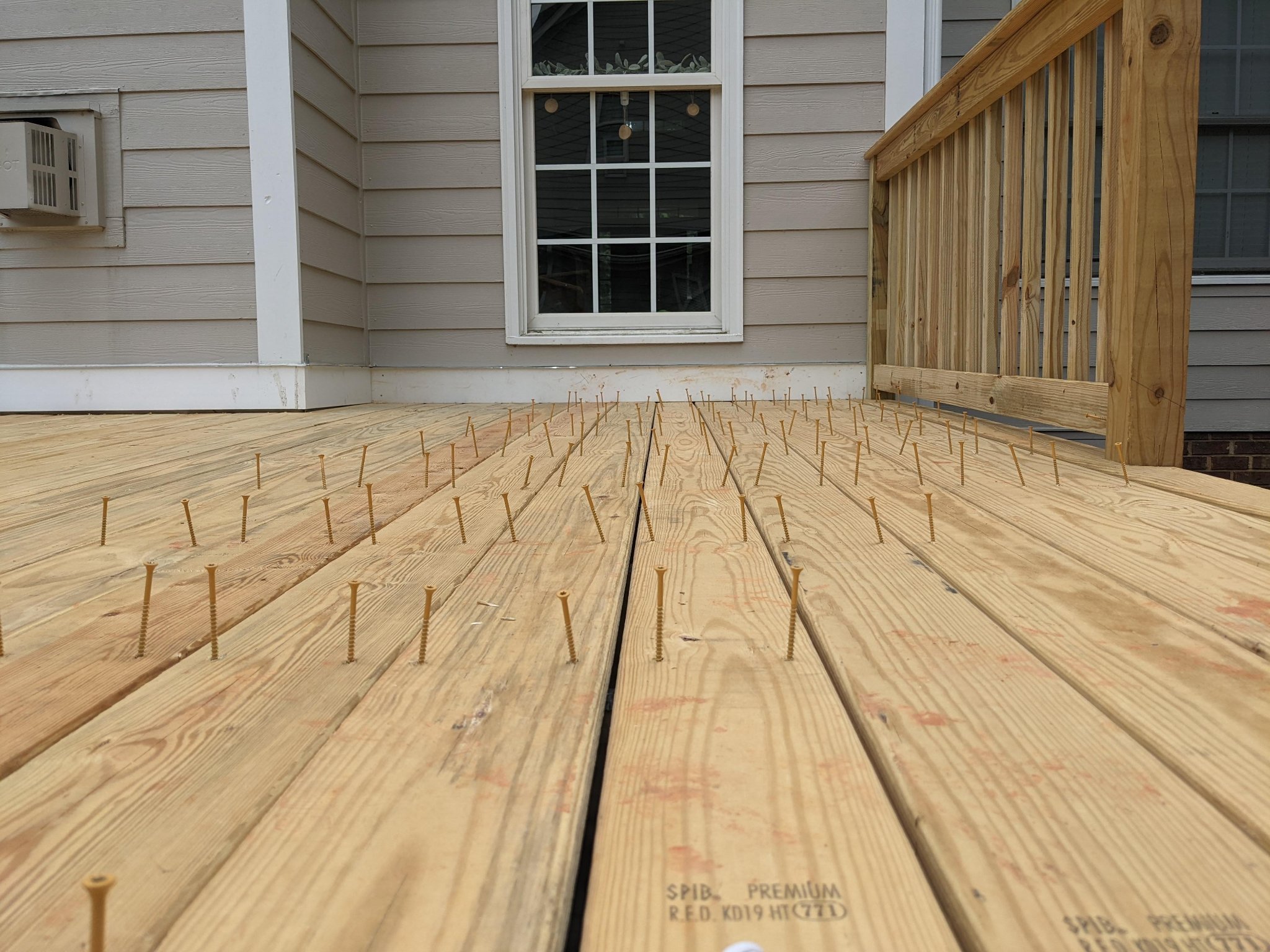 Pressure-treated deck boards being installed with screws during deck construction in Raleigh NC