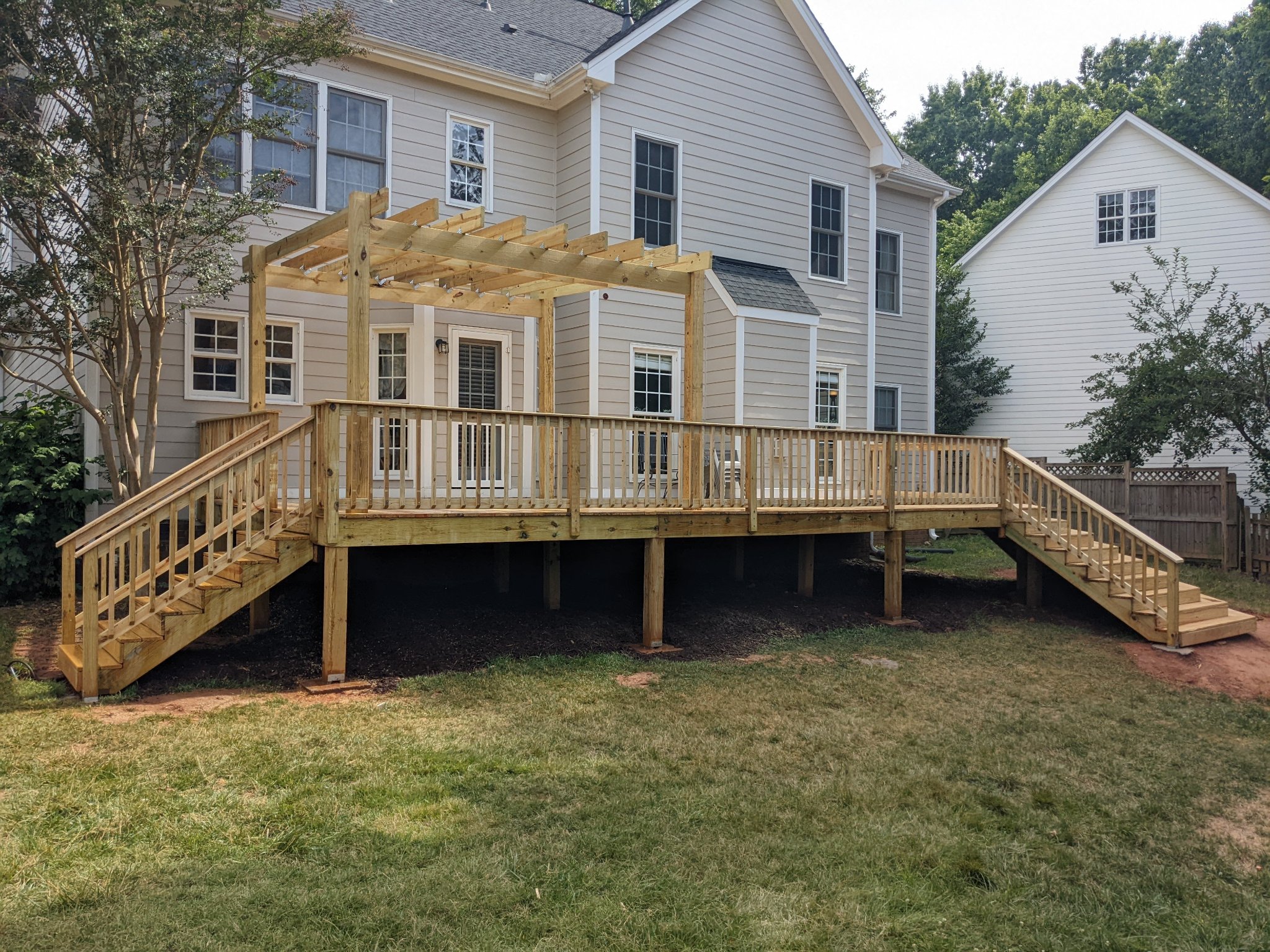 Custom elevated pressure-treated deck and pergola outdoor living space in Raleigh NC
