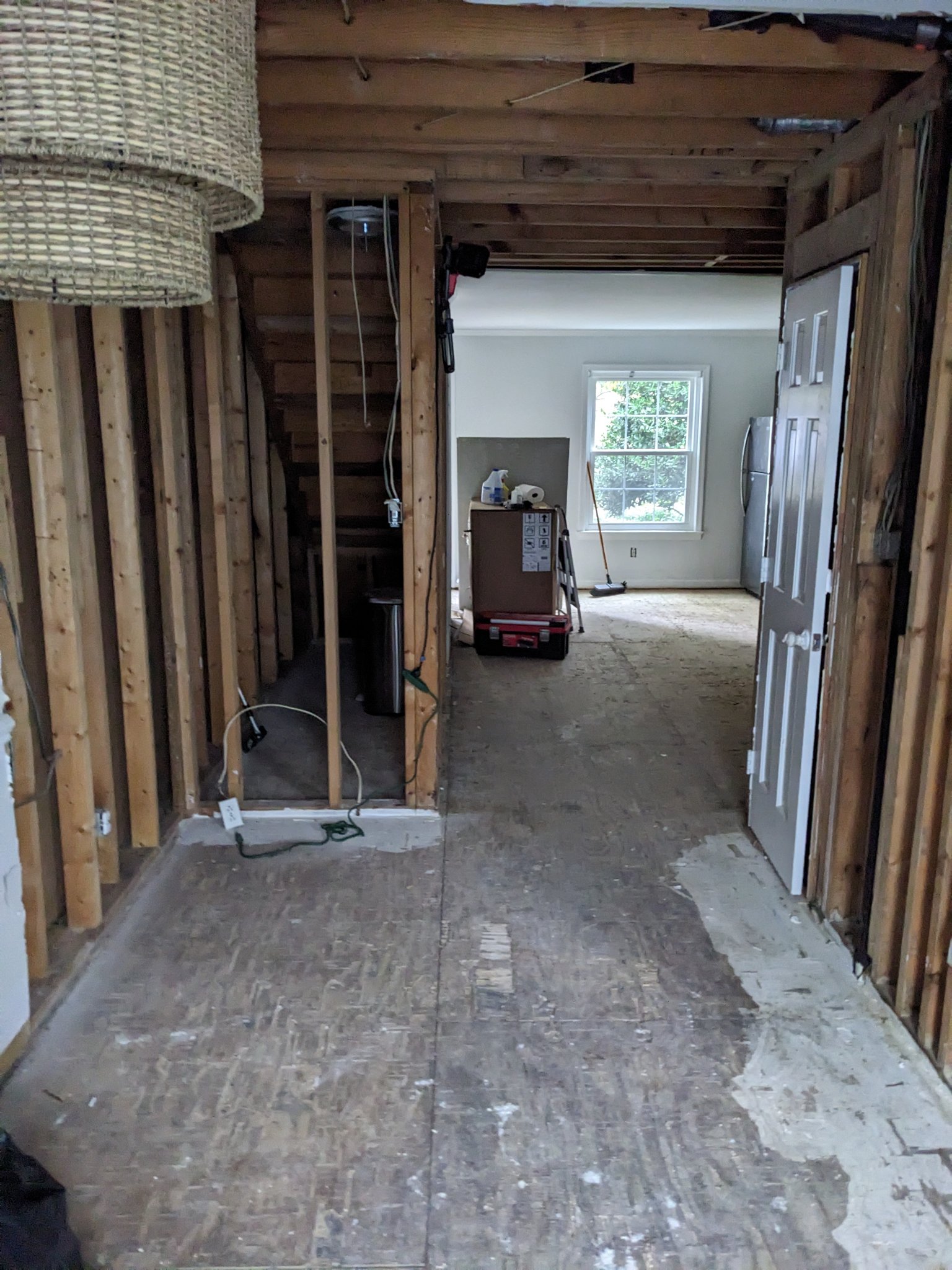 Open floor plan with walls stripped to studs and subfloor exposed during demo in Raleigh townhouse