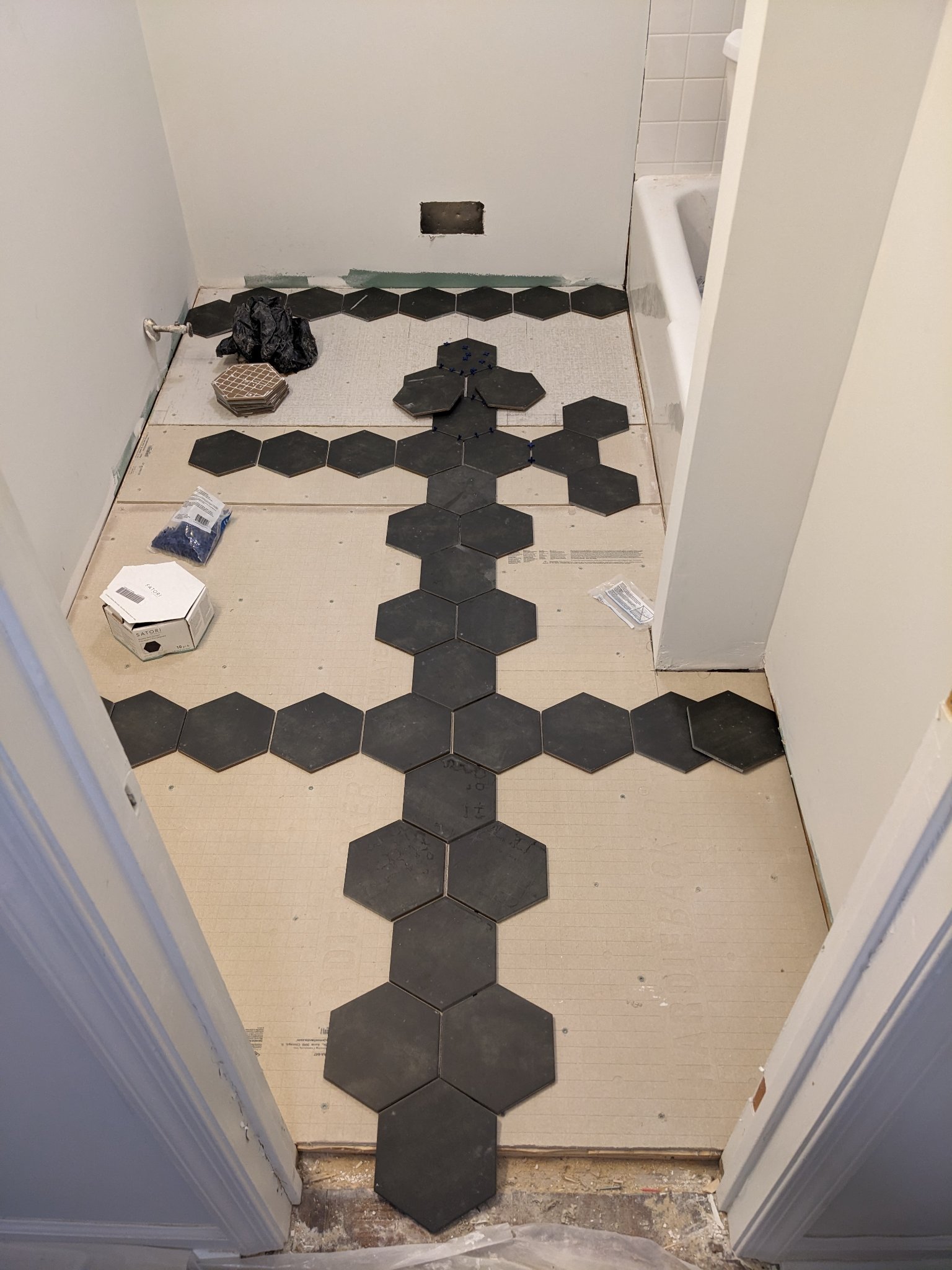 Large format hex tile being dry-fit on bathroom floor during installation in Raleigh townhouse