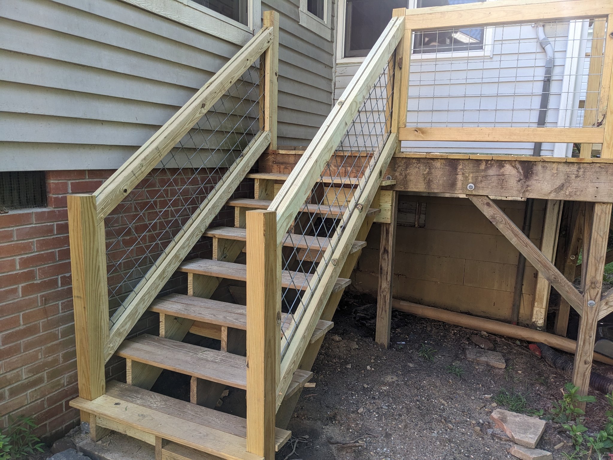 New pressure-treated stair framing with wire railing panels during construction in Durham NC